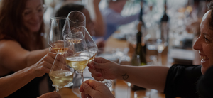 Women clinking wine glasses at a private event