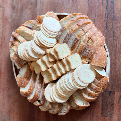Bread and crackers in a round dish on a wood table