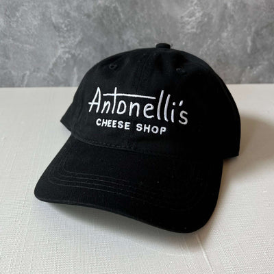 Black hat with "Antonelli's Cheese Shop" logo