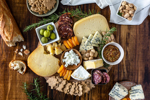 Image of four cheeses, almonds, apricots and olives