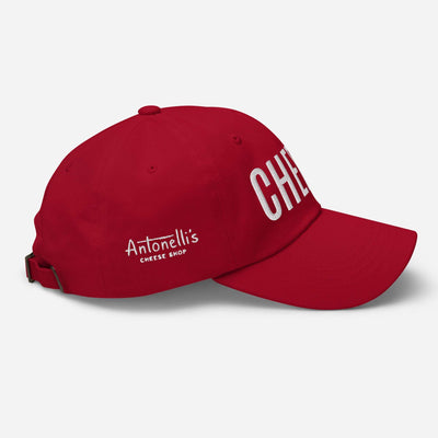 Red dad hat with "CHEESE" text and adjustable strap.