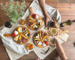 Spread of three cheese plates each with 7 wedges of cheese and 7 pairings along with wine and beer.