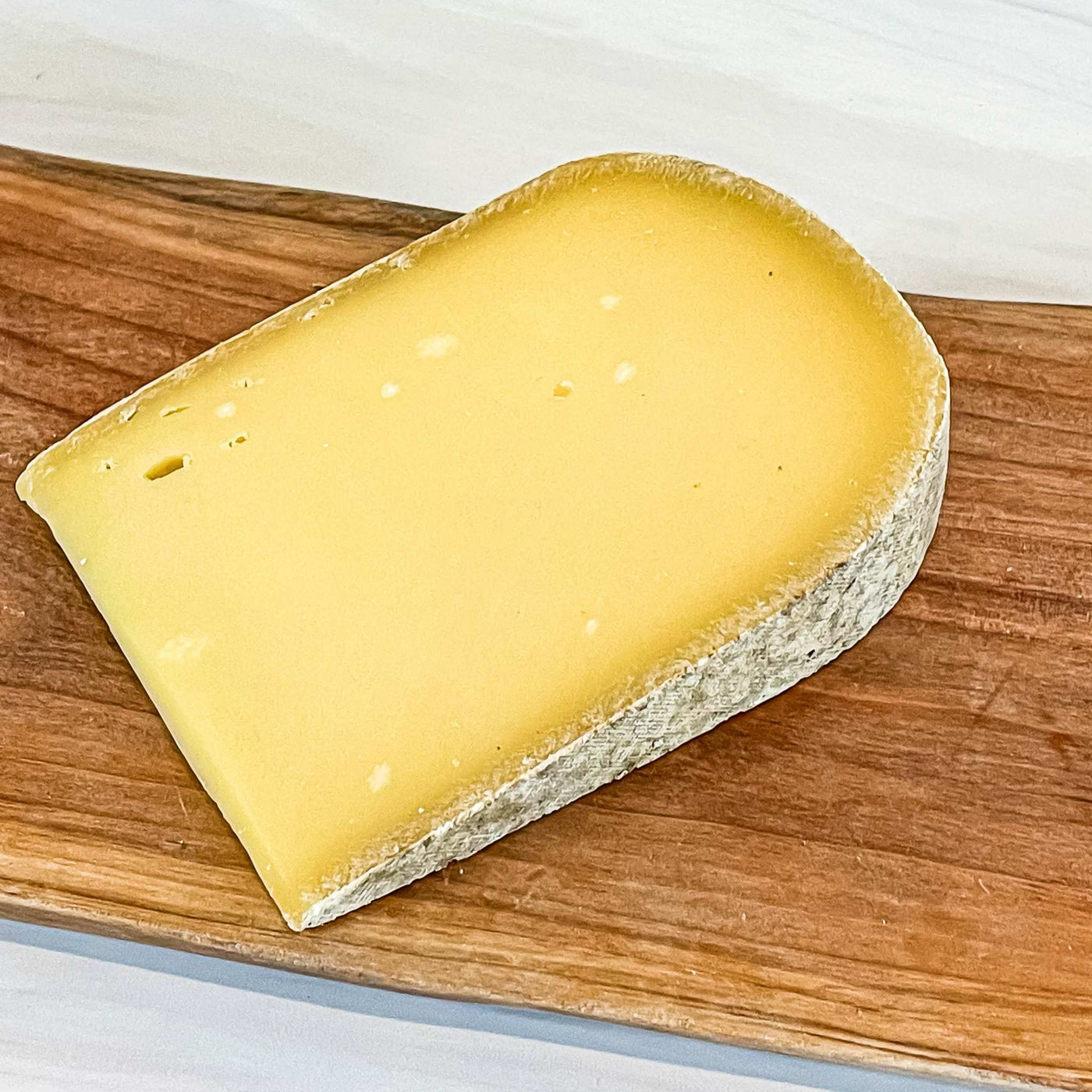 PLEASANT RIDGE RESERVE cheese from Uplands Cheese Co. on wooden board.