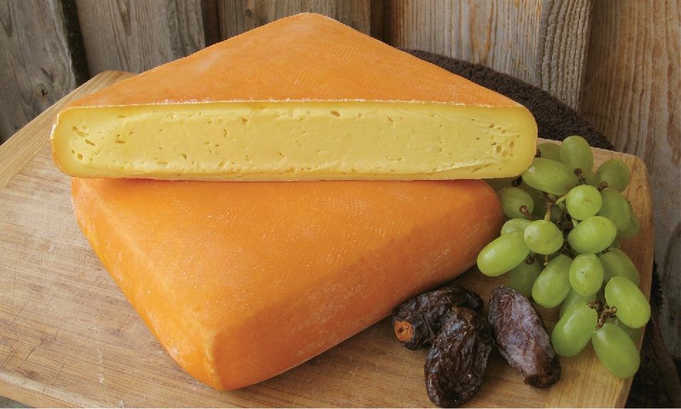 Meadow Creek Dairy GRAYSON washed rind cheese in Virginia, displayed with grapes and dates.